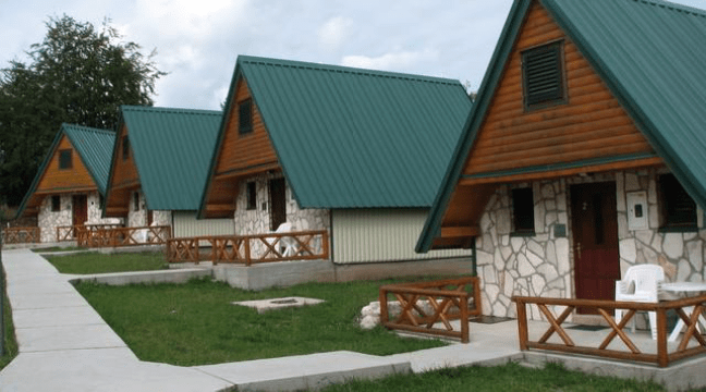 Mountain cabins with green roofs and stone porches