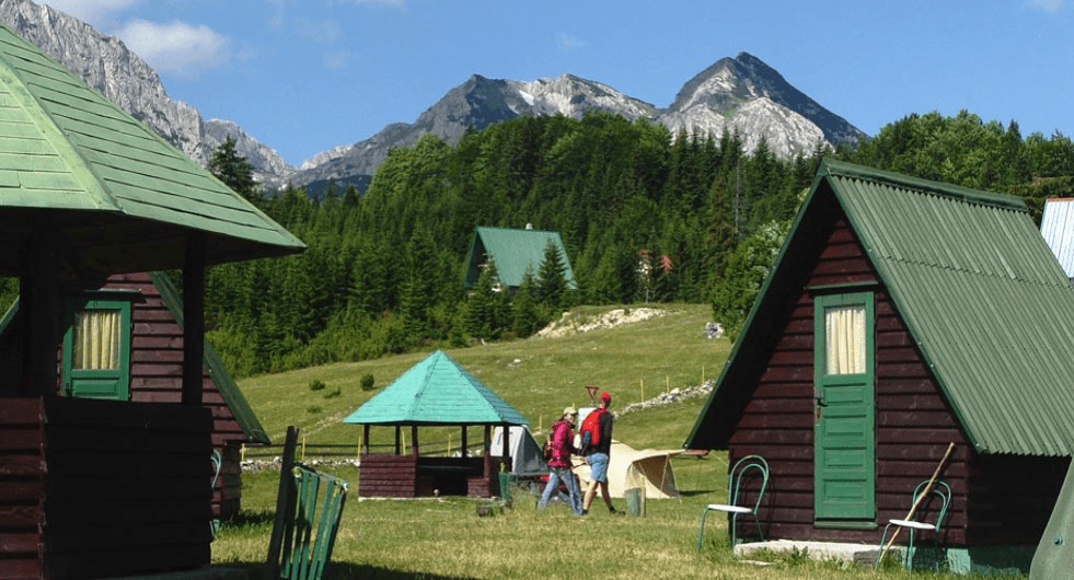 Mountain cabins and a gazebo beneath rocky peaks